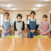 こちらを向いて手を前に組むスタッフ